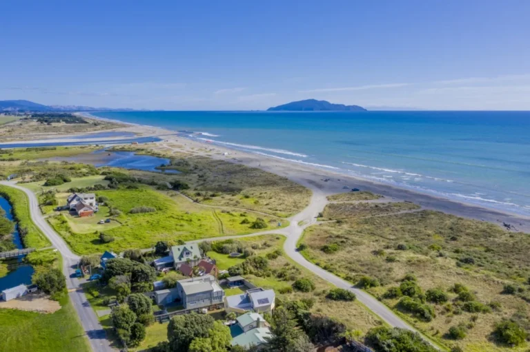 Aerial view of coastal Queensland suburb with beachfront properties — ideal location to buy investment property