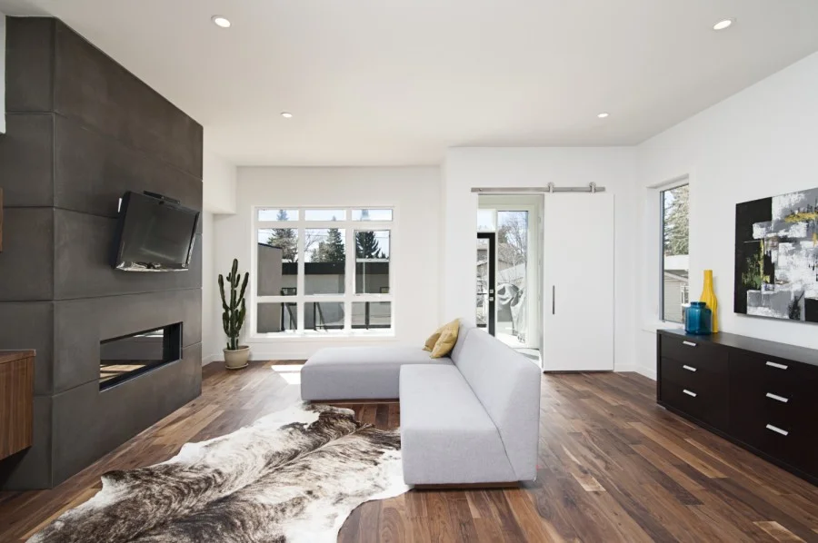 Modern living room with white sectional sofa, dark feature wall, fireplace and timber flooring
